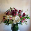 A mixture of pink, red and white flowers, including roses, hydrangea, stock