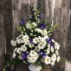 This traditional arrangement of blue iris, white daisies and snapdragons bring reminders