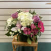 Low compact arrangement featuring white, pinks, and lavender.  Perfect for any