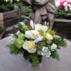 Cymbidiums and roses make up this beautiful arrangement comprised in an urn.