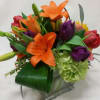 Vibrant orange lilies and purple tulips stand out against green hydrangeas and