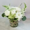 A timeless display of pure elegance, this hand-crafted arrangement features lush white