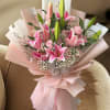 Twelve soft pink roses are artfully arranged with striking stargazer lilies and