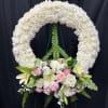 This wreath of delicate white mums exudes a serene aura, accompanied by