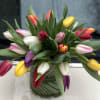A rainbow of different color tulips is arrange keeping the spontaneous feel