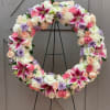 This beautiful floral wreath is filled with lilies, roses, carnations and stock