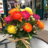 Seasonal mix of ranunculus arranged in a vase. 
