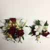 Two small floral corsages with red roses and white orchids