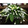 A beautiful casket spray with assorted white flowers and green leaf accents.

Flower