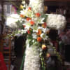 A beautiful large cross-shaped standing spray with orange and white flowers.