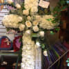 A beautiful cross-shaped spray with white carnations and white roses.

**Price does not