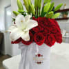 A beautiful and elegant box of red roses and lilies, adorned with