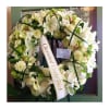 A beautiful european-style sympathy wreath in whites and a touch of green.