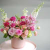 Lush and joyful, this arrangement celebrates shades of pink in a full