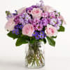 A soft and romantic mix of blush roses, lavender stock, and vibrant