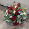 This beautifully arranged bouquet features vibrant red roses and white roses, surrounded