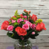 Bright colorful mix of orange roses,hot pink mini carnations,green button mums,yellow astersetc
is