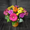 This brightly colored vase has a colorful  grouping of flowers that