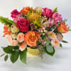 Colorful and bright flower arrangement in an elegant golden vase.