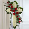 A beautiful cross with a swag of freedom red roses with baby