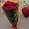 Bouquet of red roses wrapped in brown paper with a red ribbon