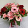 This beautiful arrangement features a variety of reds and pinks. Using red