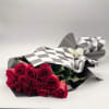 A bouquet of rich red roses, hand-tied and wrapped in chic black-and-white