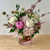 Beautiful round arrangement with a mixture of roses, spray roses, greenery, and