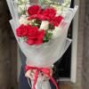 Bouquet of red and white roses wrapped in white paper with a red ribbon