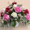 Beautiful designed 16 mixed roses in a white ceramic container. 