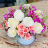 This collection of mixed pink, purple and whites blooms includes roses, spray