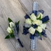 This wristlet and boutonniere combo features white spray roses with navy and