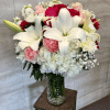 A full, luxurious floral arrangement featuring large white lilies as the focal