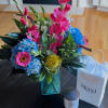 Fresh cut garden variety flowers arranged in beautiful carribean blue vase.Perfect gift