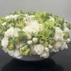 This enchanting arrangement showcases a soothing palette of lime green and ivory