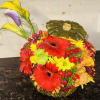 Colorful floral arrangement in a pumpkin-shaped container with calla lilies and gerberas