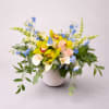 A graceful arrangement featuring vibrant yellow orchids, soft peach roses, elegant white