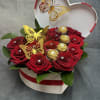 A luxurious heart-shaped box filled with rich red roses, golden butterfly accents
