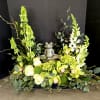 This serene floral arrangement features lush green hydrangea, tall snapdragons, elegant roses