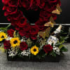 Rosas rojas con jirasoles y botella en base de madera en forma