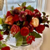 Roses, scabiosa, ranunculus, thistle, hellebores and anemones in shades of 
red, coral