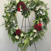 This heart-shaped wreath is designed with rich red roses, soft white alstroemeria