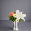 A petite, modern garden design featuring a delicate white lily, soft ranunculus