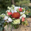 A luxurious Fall arrangement in whites including peonies, roses, and stock accented