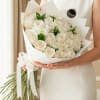 A stunning and elegant hand bouquet of 24 pristine white roses, beautifully