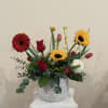 A beautiful garden style arrangement, with red roses, sunflowers, tulips, green trick.