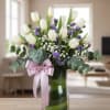, this exquisite arrangement features  pristine white tulips, delicately complemented by