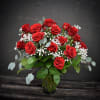  24 red roses designed in a clear glass vase with assorted