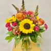 This Spring Bouquet includes Sunflowers, Orange Roses, Snapdragons and Hot pink Mini