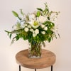 This serene arrangement highlights premium white lilies mixed with white roses, spray